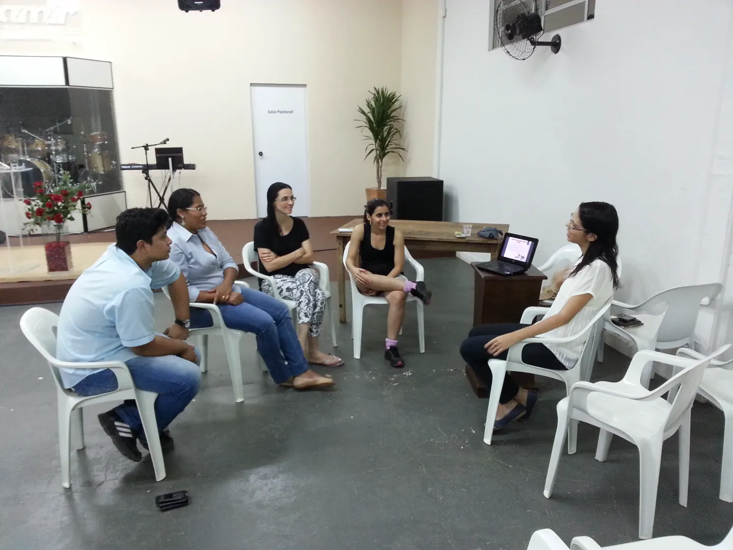 Pequeno grupo reunido em círculo no antigo salão da IAMIR.